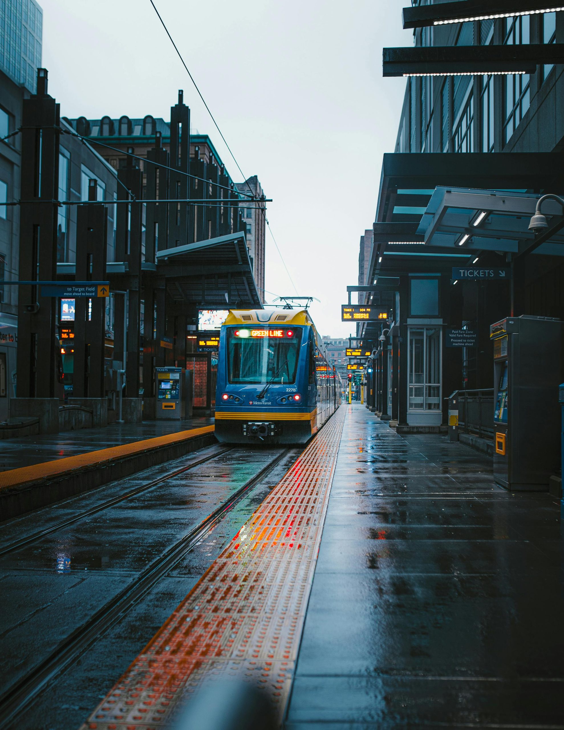 A vibrant tram at a wet station in downtown Minneapolis, showcasing urban transit.